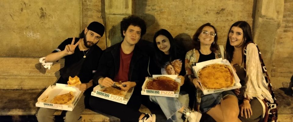 5 fiatal ül egy épület padján ölükben pizzákkal