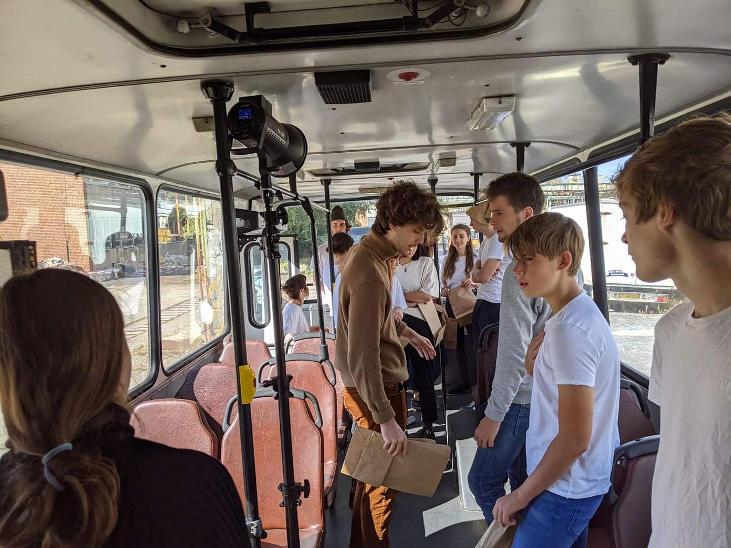 Fiatalok csoportja egy régi Ikarus buszban beszélget az ülések között 