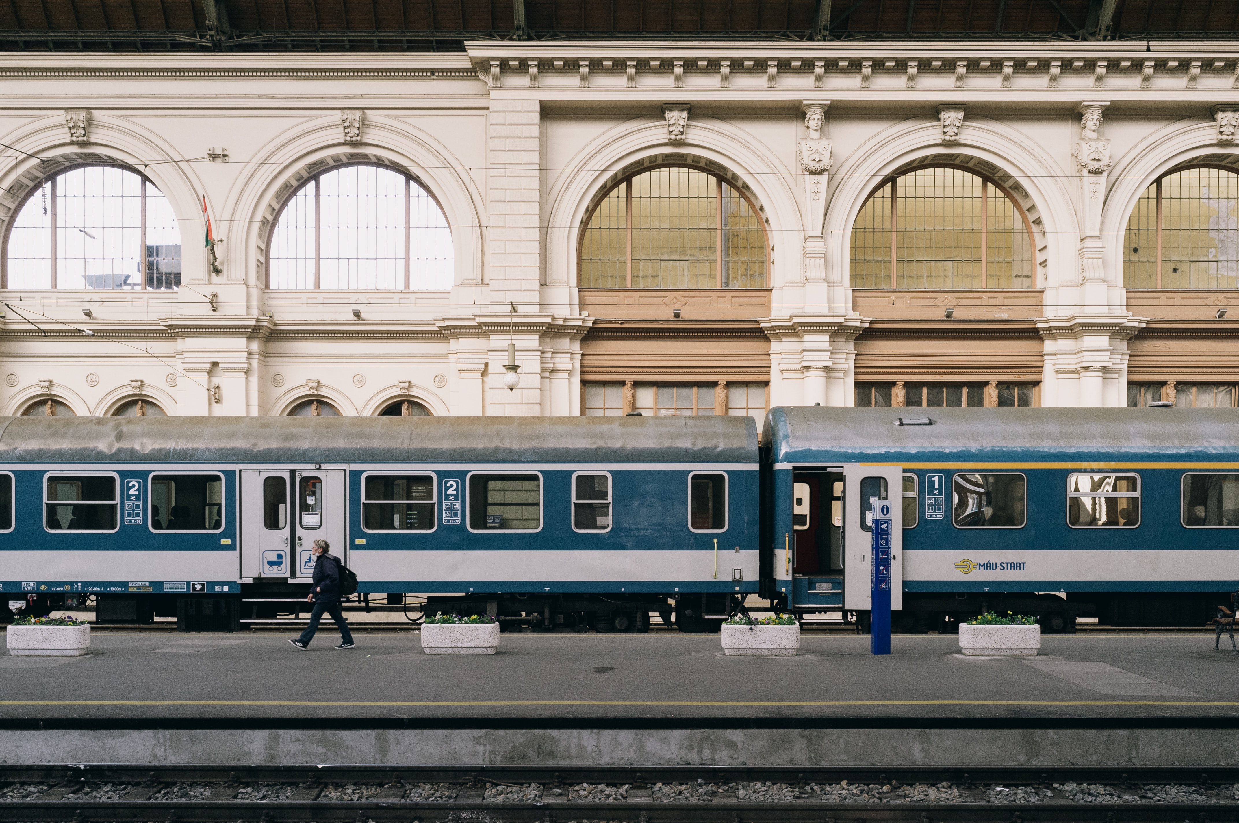 Nyugati pályaudvar belső terében az árkádos oszlopos falak előtt áll egy vonat a sínen