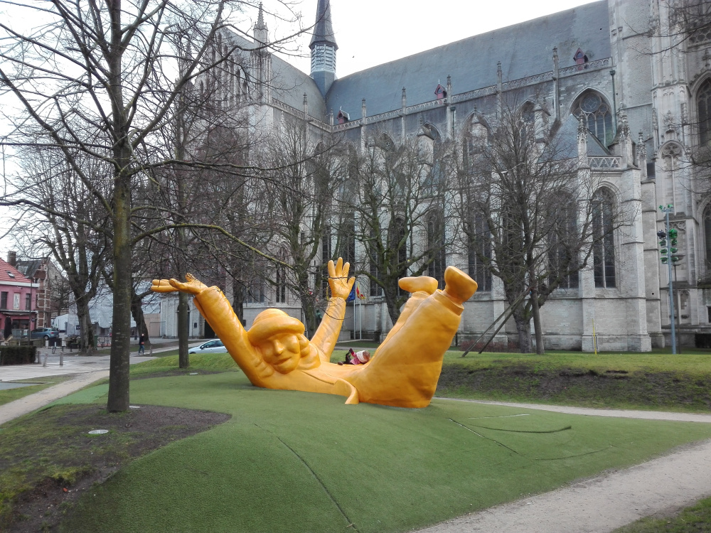 Belgium Mechelen város egykori székesegyháza előtti templomkertben hatalmas sárga Opsinjoorke emberszobor